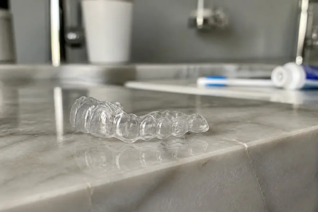 Gouttière dentaire pour la nuit sur lavabo en marbre avec brosse et dentifrice