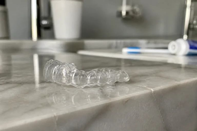 Gouttière dentaire pour la nuit sur lavabo en marbre avec brosse et dentifrice