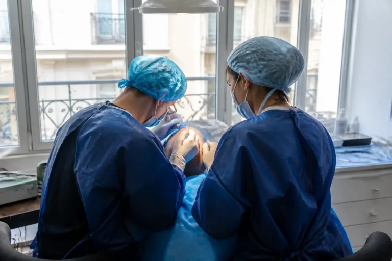 Deux médecins effectuent une greffe capillaire racine carrée en milieu médicalisé.